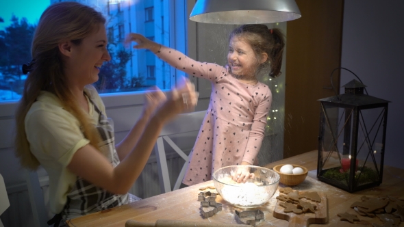 Young Mother and Her Little Daughter Play with Flour