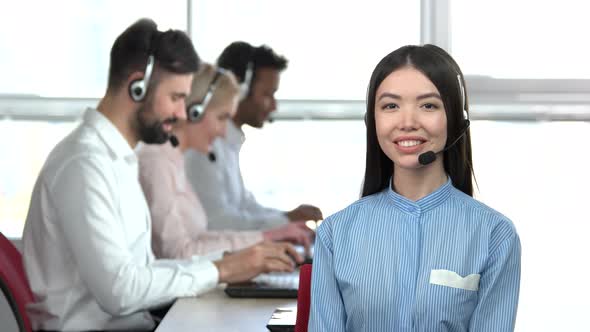 Asian Girl in Office Praising Her Colleagues.