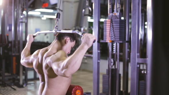 Brutal Man Using The Lat Pulldown Machine