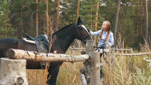 Love and Understanding Between Girl and Horse. Redhead Girl and Brown Horse in the Forest.