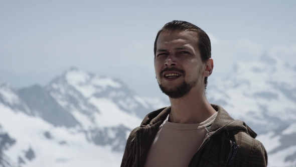 Young Bearded Man at Mountain Top with Scenic View Appears in Shot