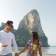 Couple Walking On Beach Holding Hands Talking Young Man And Woman Tourists On Vacation - VideoHive Item for Sale