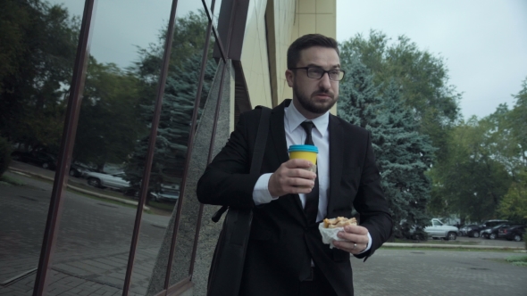 Businessman Eating Burger and Drinking Coffee