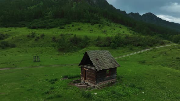 Lonely old abandoned house in the mountains in summer. Green background