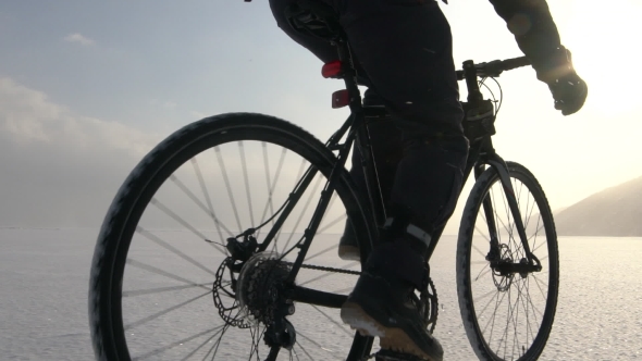 Man Riding a Bicycle Across a Frozen Lake