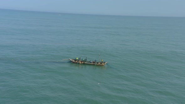 Fishermen at sea casting net in Ghana