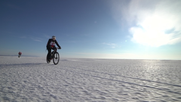 a Man Riding a Bicycle Across a Frozen Lake