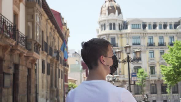 Young tourist in a medical protective black mask visits the sights on a trip to Europe and Spain. 