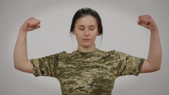 Brave Confident Military Woman Gesturing Strength Gesture Looking at Camera