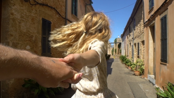 Young Woman Leading a Man To the Adventure in an Old European Town