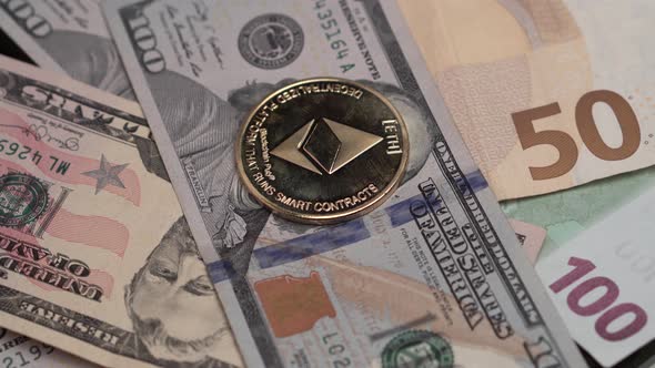 Ethereum ETH Cryptocurrency Golden Coin on American Dollars and Euros Banknotes