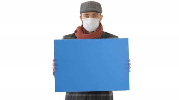 Man in a Trendy Outfit and Medical Mask Holding Blank Placard on White Background