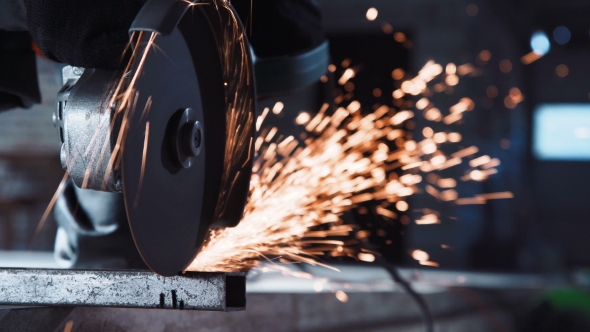 Unrecognizable Worker Cutting with Angle Grinder