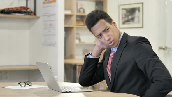 Tired African Businessman with Neck Pain Working on Laptop