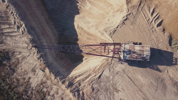 Flying Over the Excavator in a Quarry. Aerial Survey in