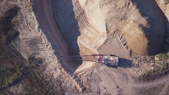 Flying Over the Excavator in a Quarry. Aerial Survey