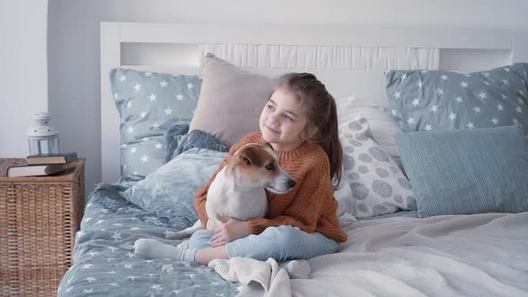 Portrait of Young Beautiful Girl Playing with Her and Hugging Adorable Jack Russell Terrier Puppy on