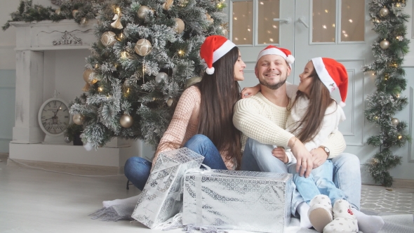 Portrait of Friendly Family in Santa Caps on Christmas.