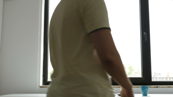 Man Is Taking a Cup of Coffee and Donut From the Plate