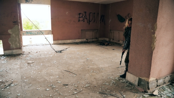 Young Attractive Military Woman Holding Automatic Rifle and Looking at Camera