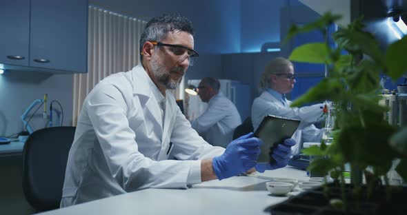 Scientist Taking a Photo of Green Plant alt