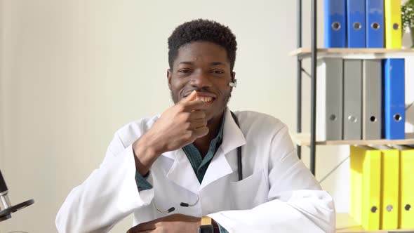 Young African American Male Doctor Looking Directly to the Camera While Sitting in Hospital