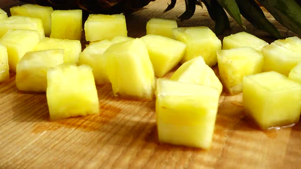 Pieces of pineapple on a cutting wooden board.