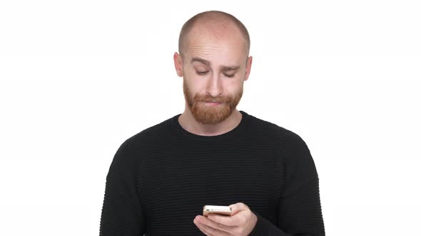 Portrait of Handsome Man in Black Sweatshirt Using Smartphone Scrolling Feed or Reading News Being