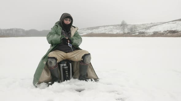 Man is fishing in ice hole