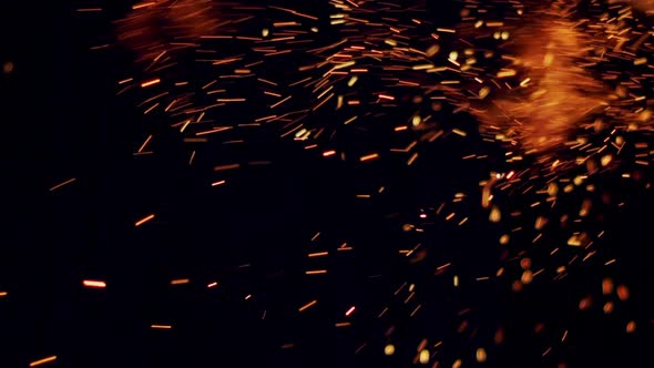 Burning Redhot Sparks Rise From Large Fire in the Night Sky in Slow Motion