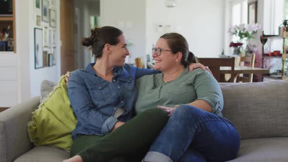Portrait of caucasian lesbian couple looking at camera, embracing