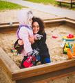 Mother playing with her daughter in a sandbox - PhotoDune Item for Sale