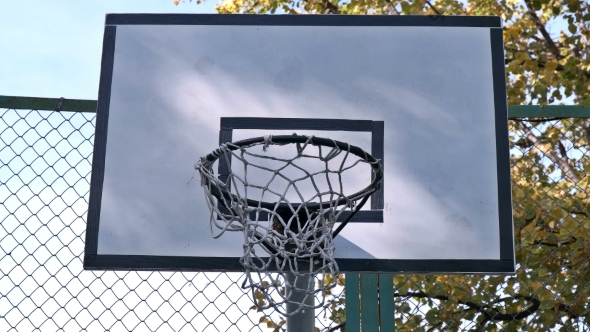 the Basketball Enters the Basket Outdoors