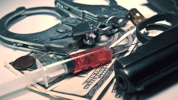 Handcuffs with Keys, Money and a Syringe with Drugs