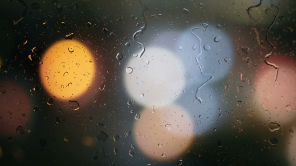 Raindrops on a Car Window with Blurred Background of Street Traffic Lights