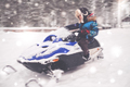 Boy driving snowmobile in a winter landscape - PhotoDune Item for Sale