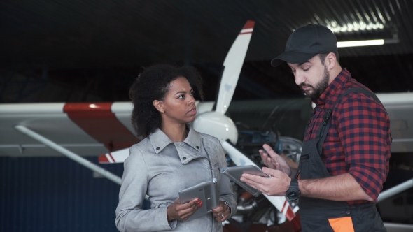 Pilot and Mechanic Discussing Aircraft Repairs