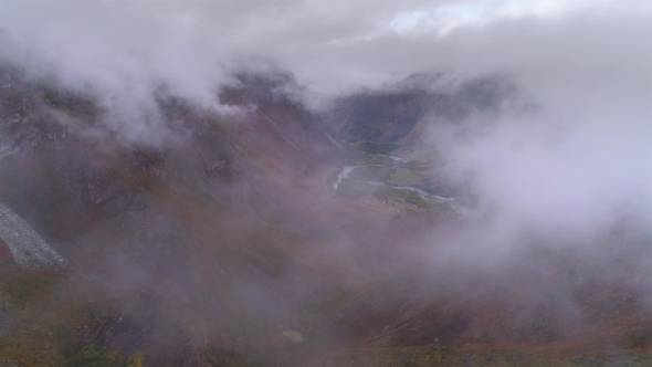 Aerial Footage of a Cloudy Mountain Valley. Flight Over
