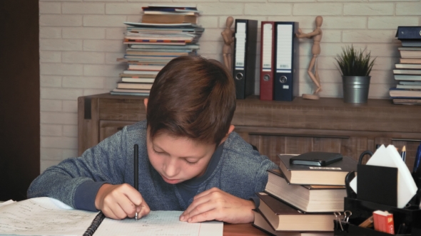 Little Boy Distracted by the Smartphone from Doing Homework