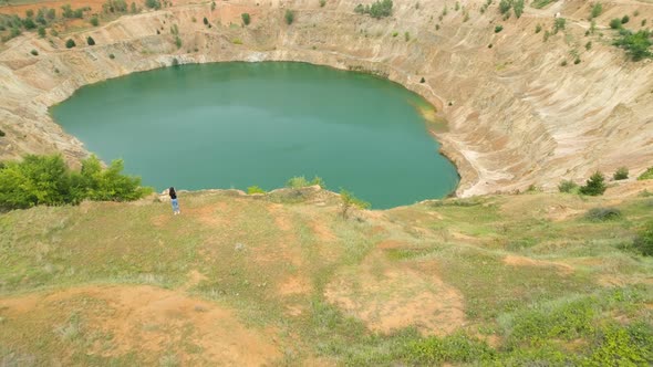 Aerial View of Lonely Woman Staying Still Near Abandoned Copper Mine Pit and Enjoying the View