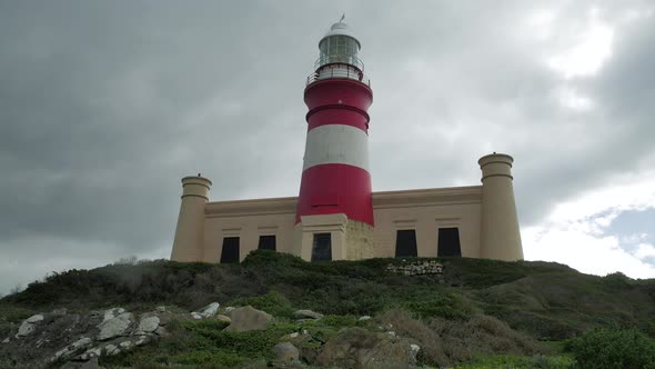 Cape Agulhas lighthouse against moody skies, panning shot