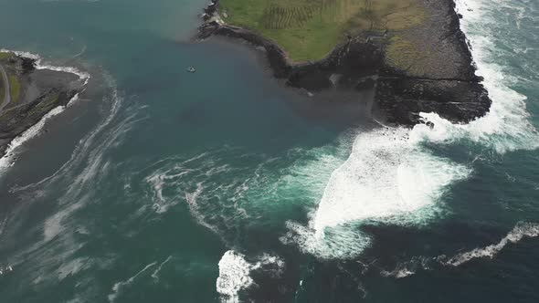 Aerial top view of rocks in the sea - Aerial video of majestic waves splashin