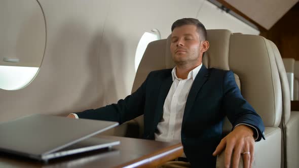 Young Entrepreneur Sleeping in Comfortable Armchair Inside of Air Private Jet