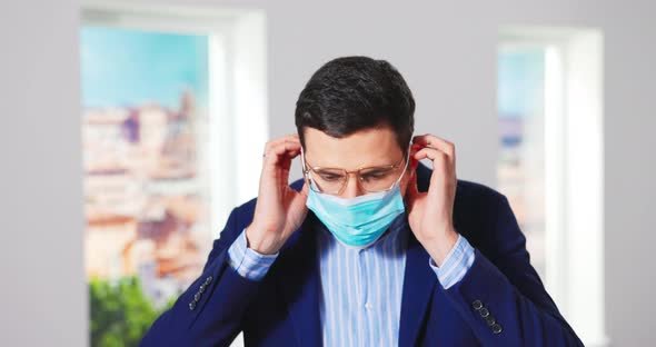 Closeup of Young Caucasian Man Real Estate Agency Manager Putting on a Protective Medical Face