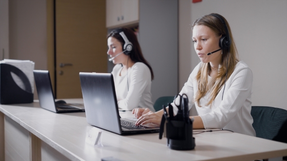 Employees Women Are Sitting at Tables with Headphones with a Microphone on Heads, Doing Outbound