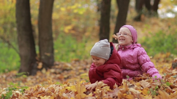 Cheerful Children Playing in Leaves Pile in Autumn