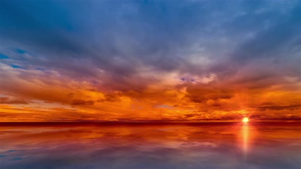 Beautiful cloudscape and sunset breaking through cloud over lake.  Time lapse 4K alt