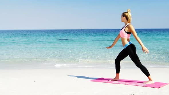 Fit woman doing stretching exercise at beach