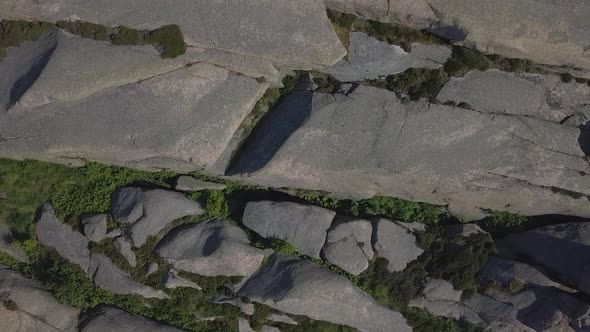 Drone ascend, zooms up into the sky with rocky coastal terrain