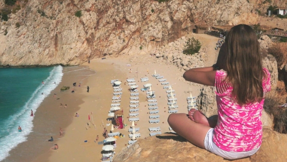 Woman Meditating On Cliff Above Sand Beach